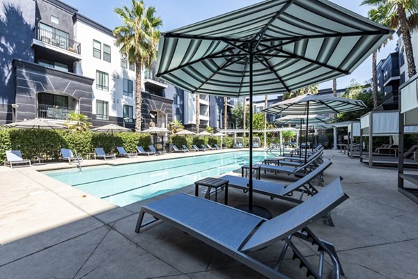 Luxurious outdoor pool at The Gallery at NoHo Commons Apartments featuring modern design and lounge chairs
