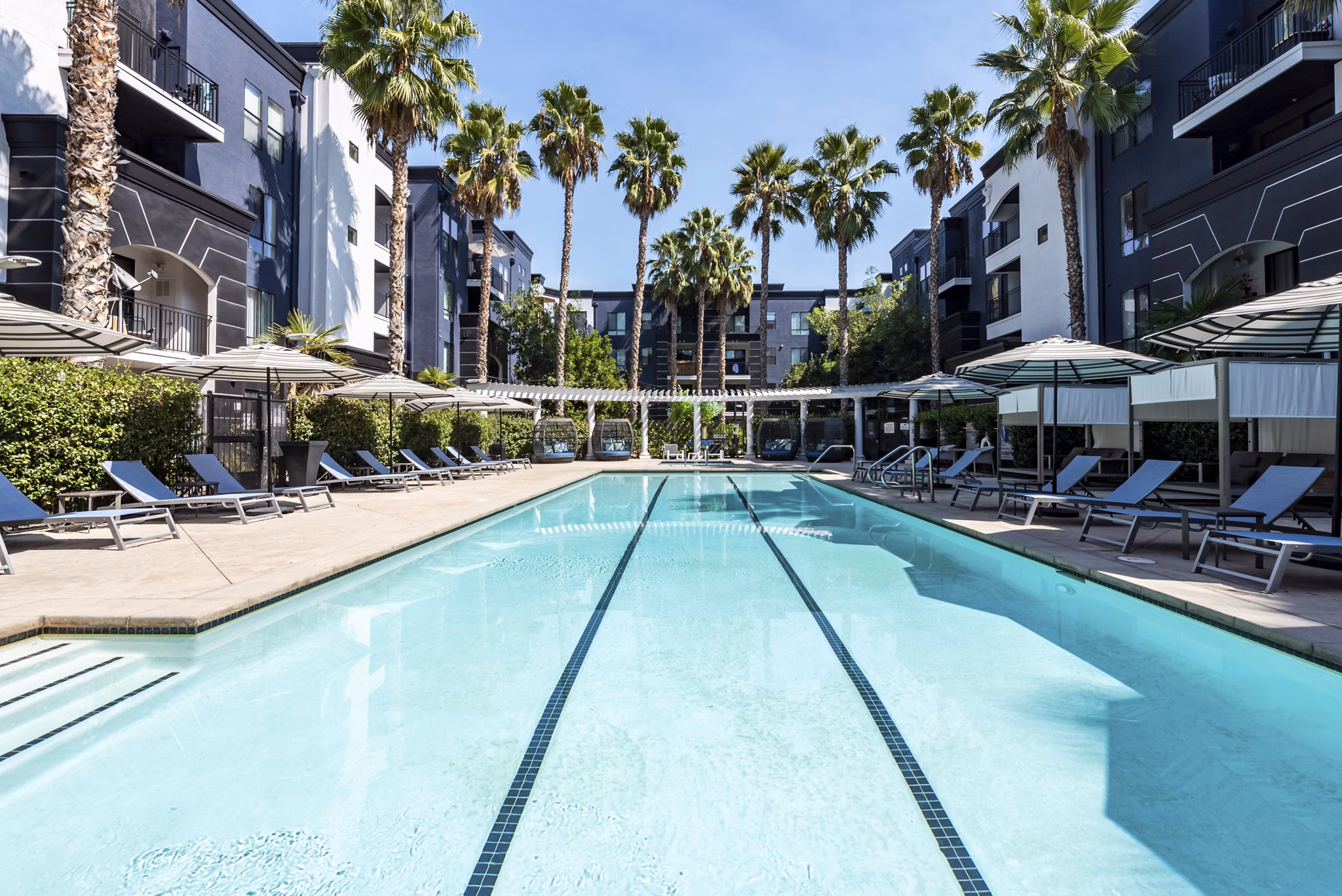 Outdoor pool area with lounge chairs at The Gallery at NoHo Commons Apartments, perfect for relaxation and enjoying the sun