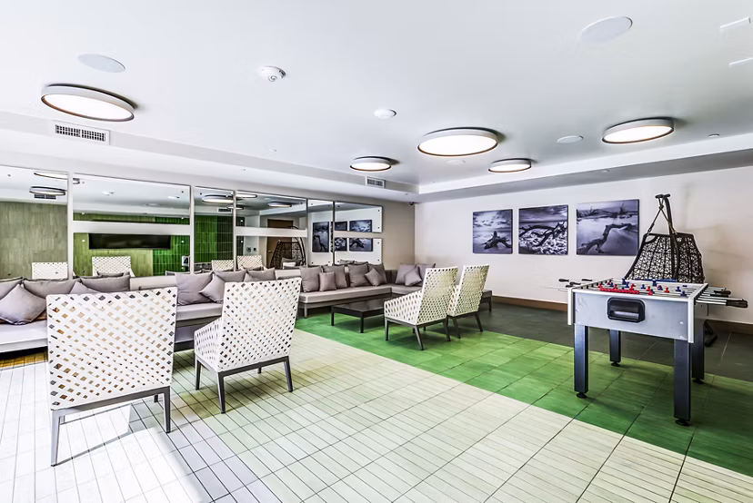 Luce Apartments: Cozy patio game room with seating areas and pool table for leisure and entertainment