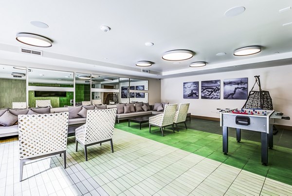 Luce Apartments: Cozy patio game room with seating areas and pool table for leisure and entertainment