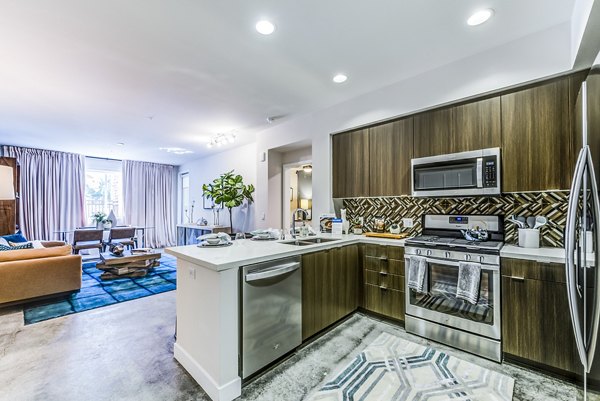 Modern kitchen with stainless steel appliances and granite countertops in Luce Apartments