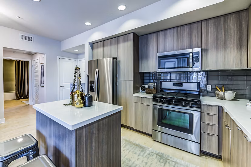 Modern kitchen with stainless steel appliances and quartz countertops in Luce Apartments