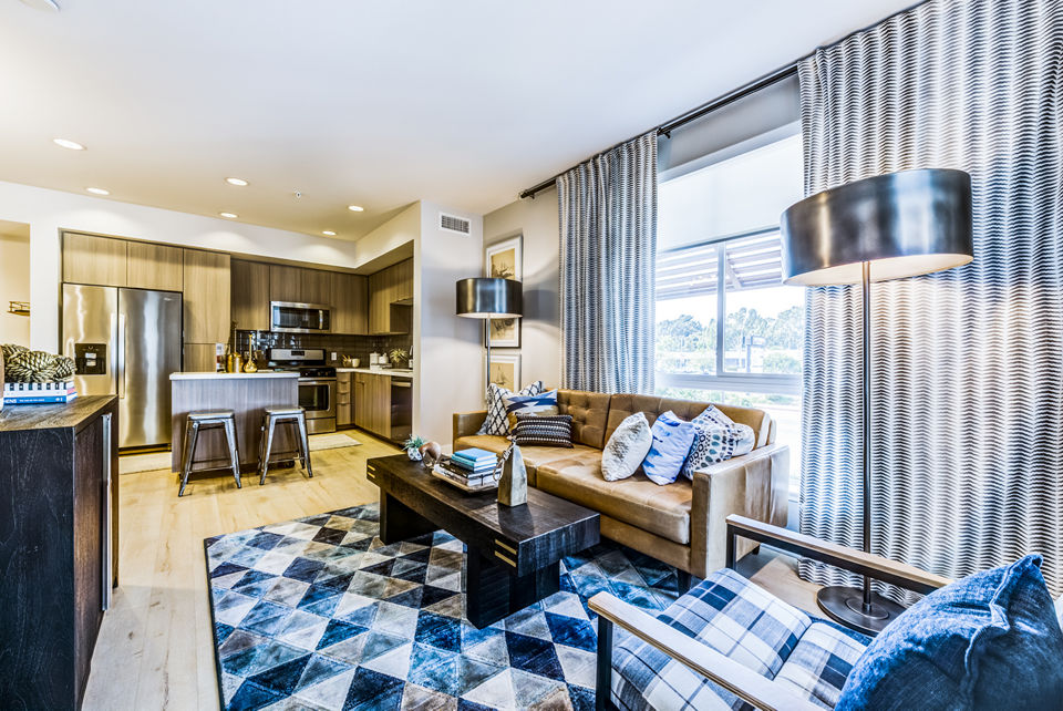 Modern living room with sleek furnishings and large windows at Luce Apartments, offering luxury living in a stylish setting