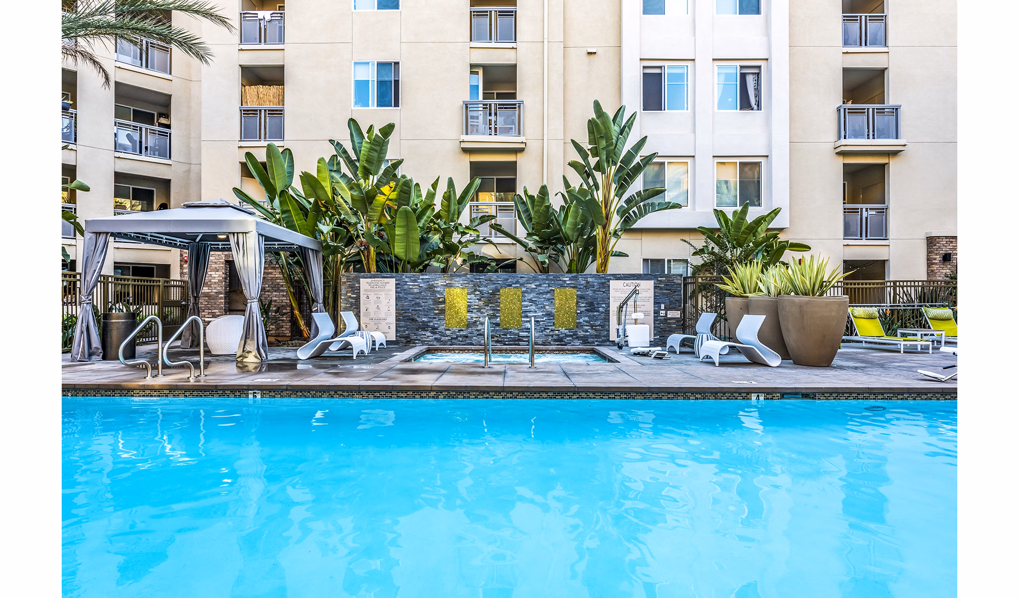 Luce Apartments: Luxury pool with lounge seating and landscaped surroundings