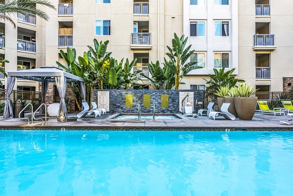 Luce Apartments: Luxury pool with lounge seating and landscaped surroundings