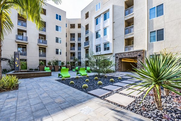Luce Apartments: Serene courtyard with lush gardens and seating areas in luxury community