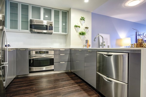 Modern kitchen with stainless steel appliances and granite countertops in Argenta Apartments