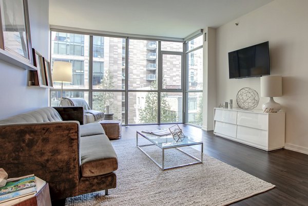 Spacious living room with modern decor featuring large windows at Argenta Apartments, luxury living space for comfort and style