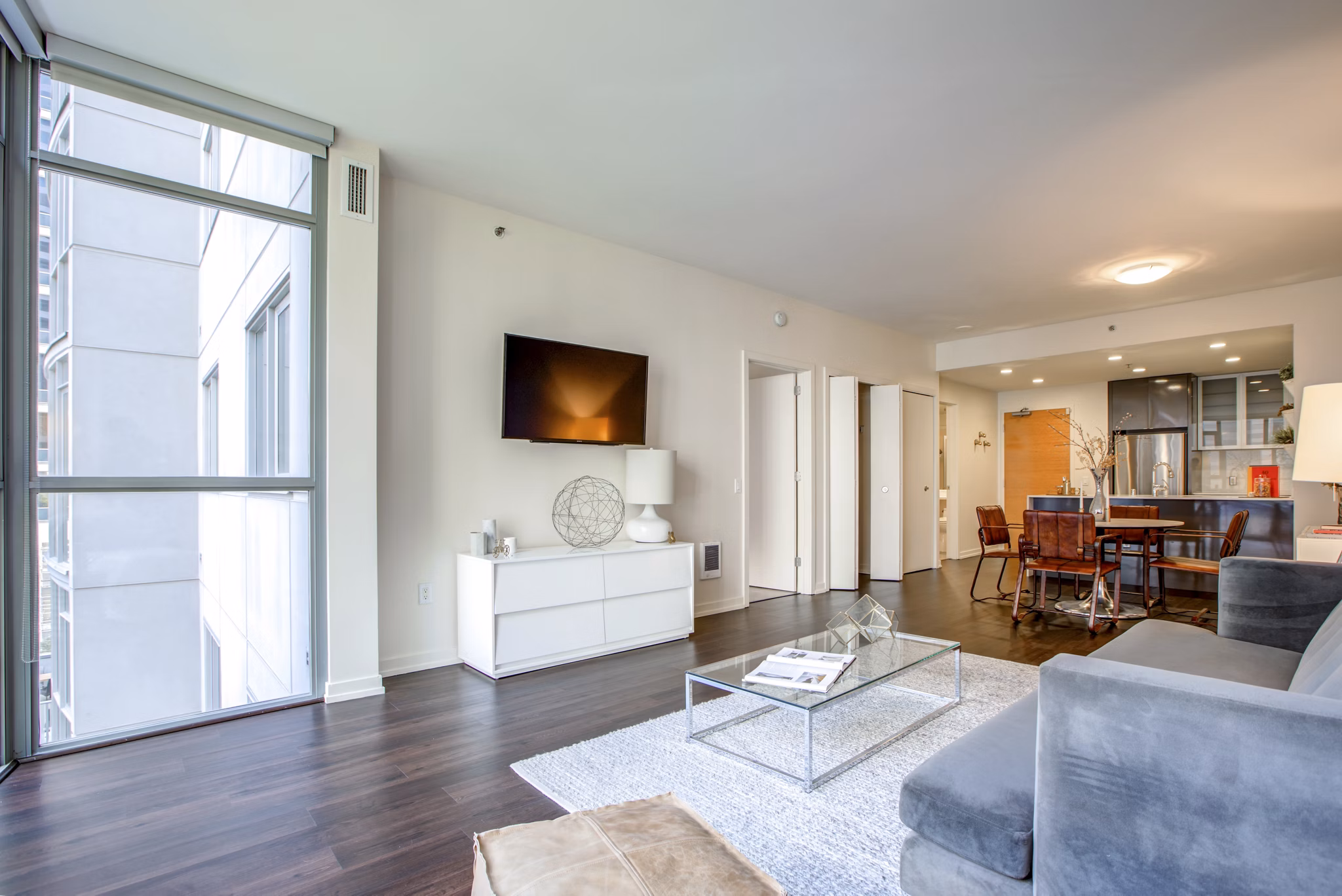 Spacious living room with modern decor and city views in Argenta Apartments, showcasing luxury Greystar design