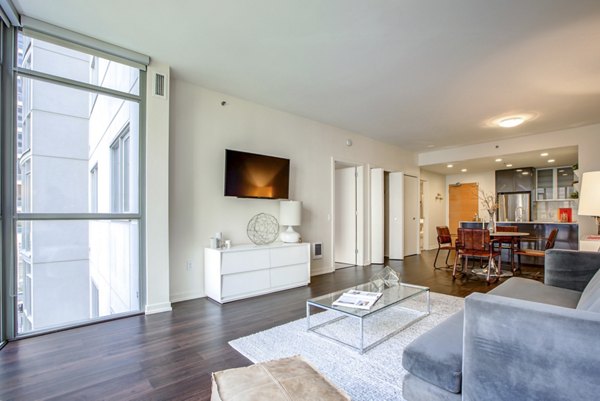 Spacious living room with modern decor and city views in Argenta Apartments, showcasing luxury Greystar design