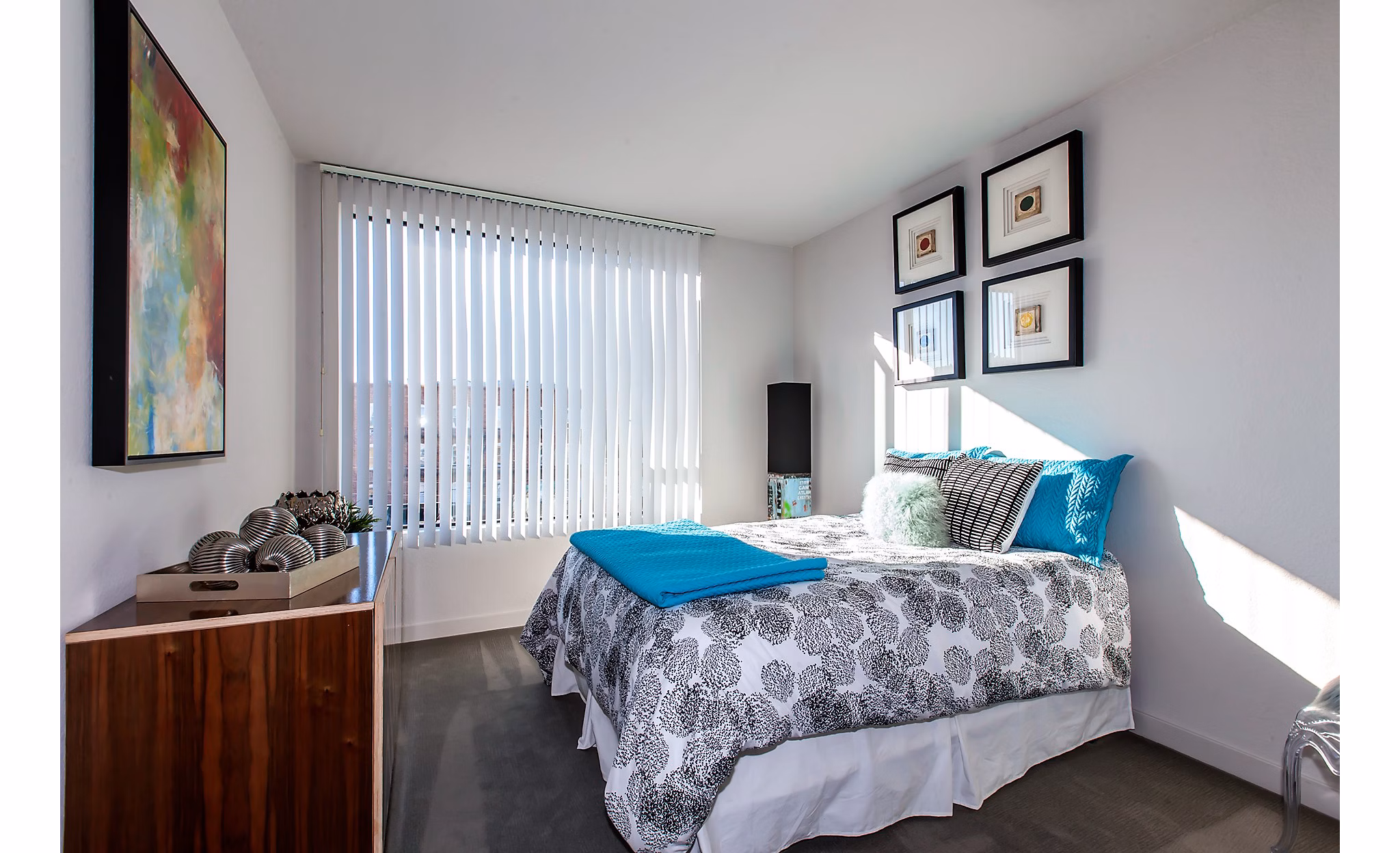 Modern bedroom featuring decorative pillows and artwork at luxury apartments