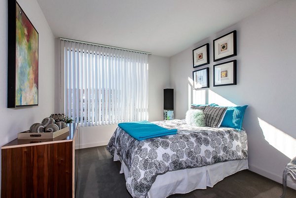 Modern bedroom featuring decorative pillows and artwork at luxury apartments