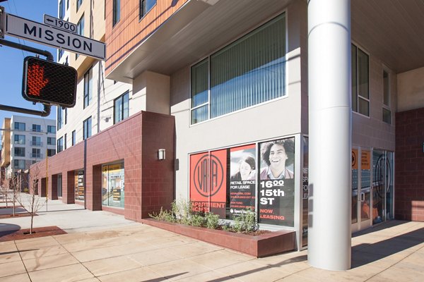 Retail spaces available for lease at a street corner building with a Mission street sign and traffic light