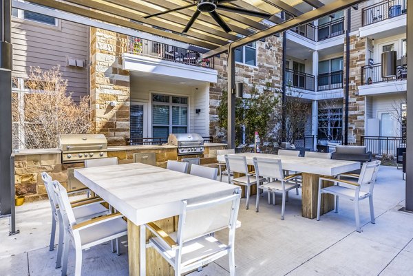 Outdoor patio with a modern grill area at Overture Arboretum Apartments, perfect for entertaining and relaxation