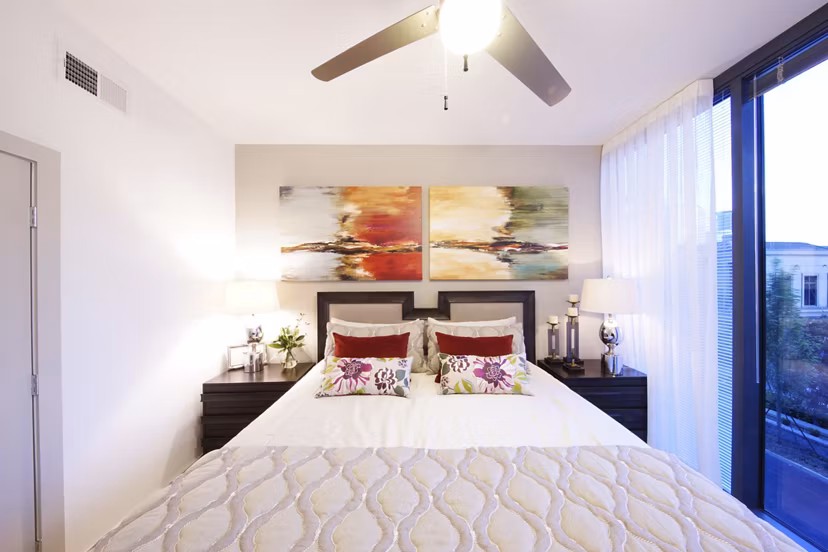 Cozy bedroom with decorative pillows and lamps in luxury apartments