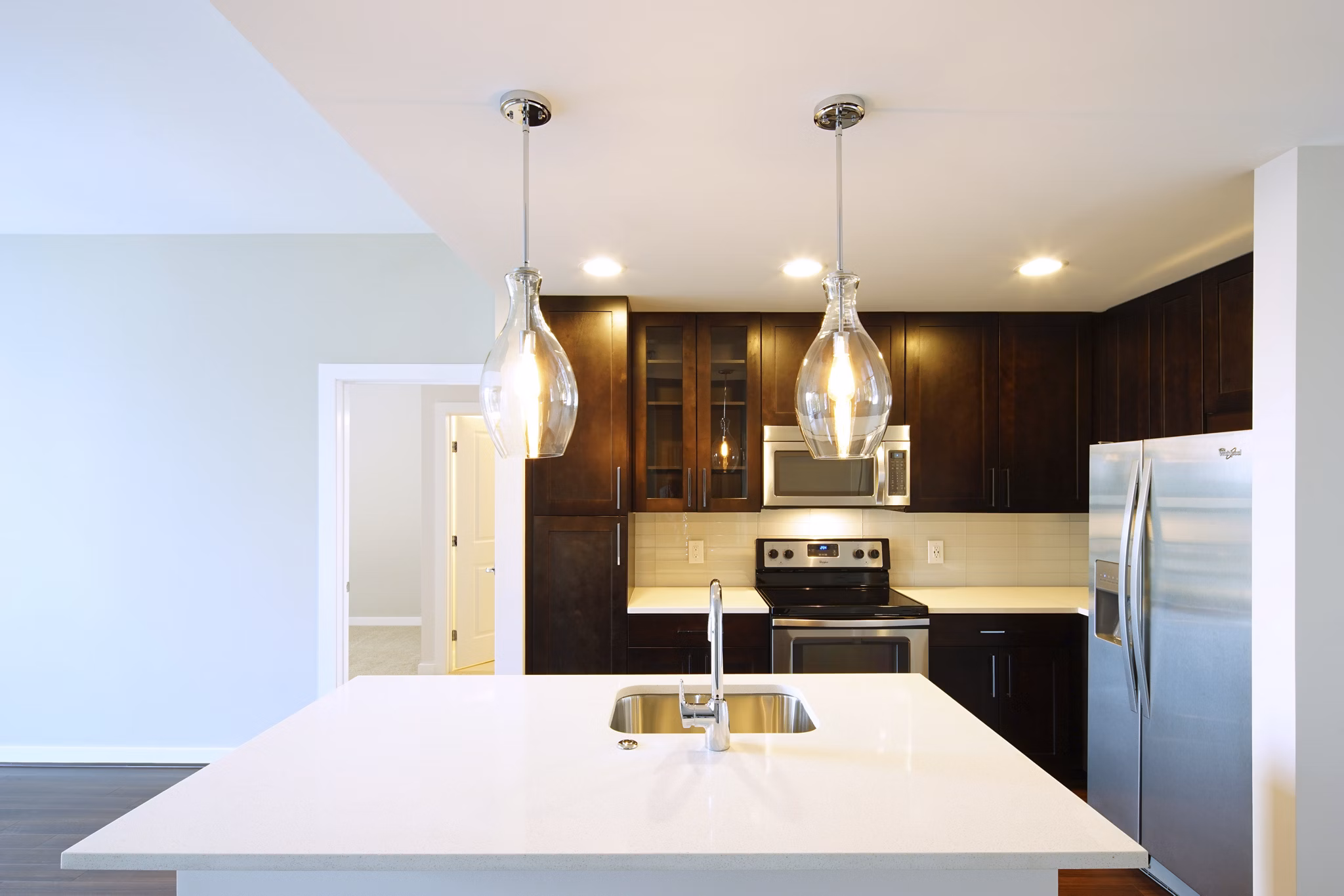 Modern kitchen featuring a white island countertop and stainless steel appliances in luxury apartments