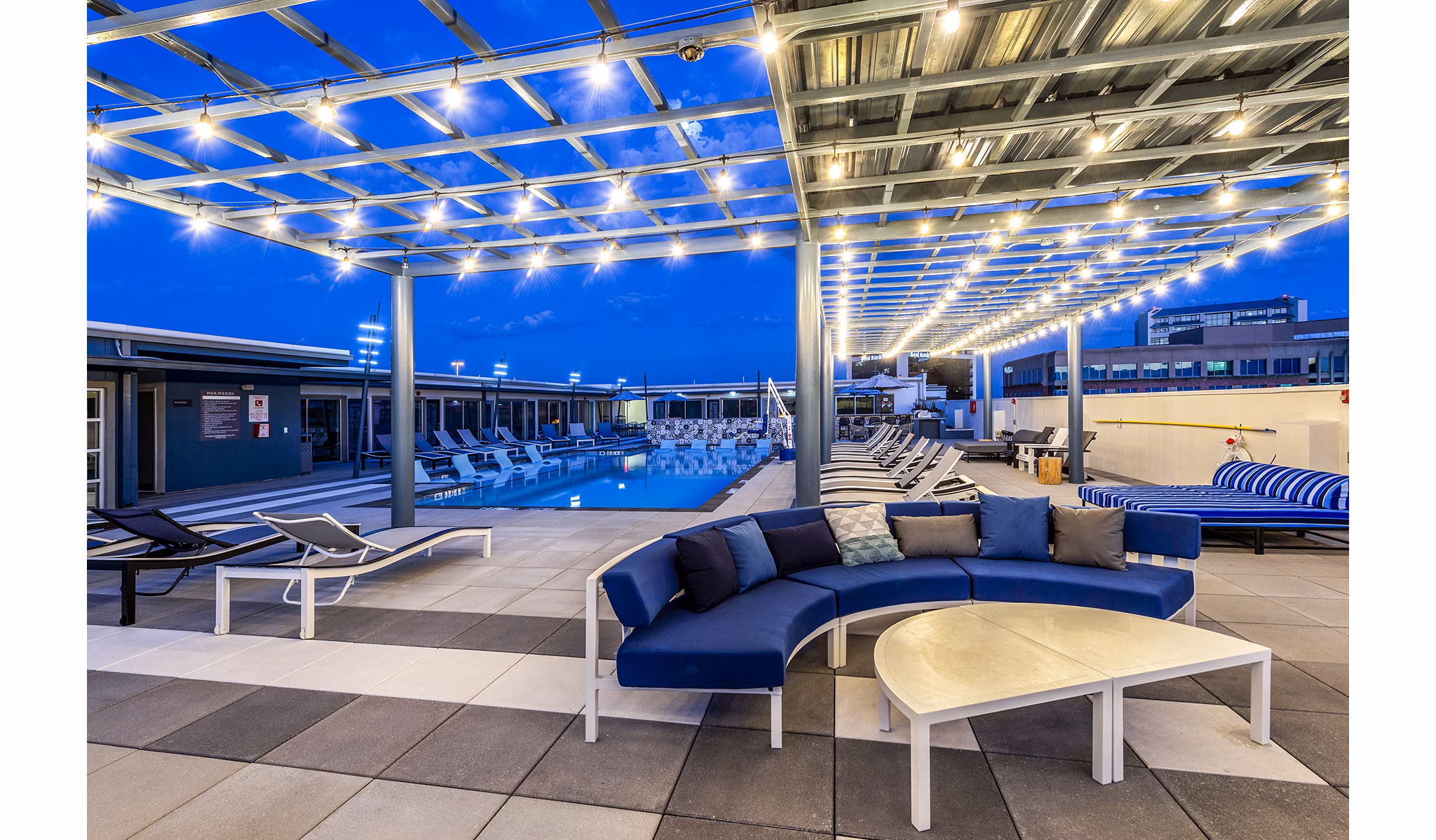 Allegro Apartments: Modern pool patio featuring lounge seating and landscaped surroundings