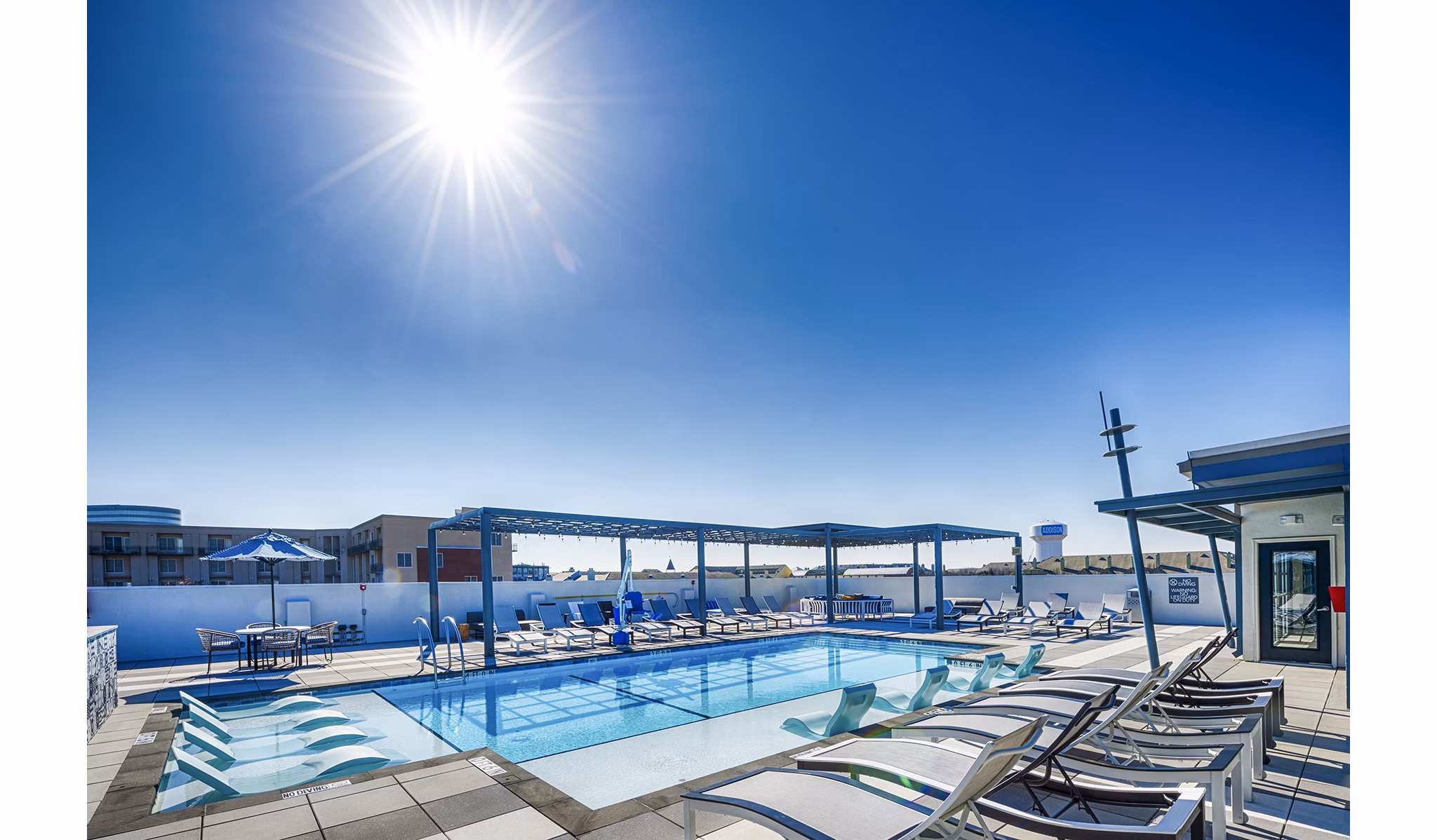 Allegro Apartments: Luxurious pool area with lounge chairs and umbrellas in vibrant community atmosphere
