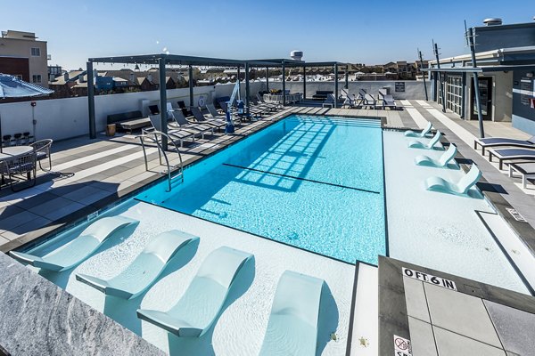 Allegro Apartments: Stunning resort-style pool area with lounge chairs and greenery in a serene setting