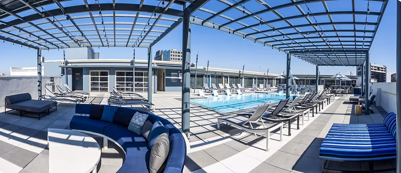 Sunny outdoor pool patio at Allegro Apartments, perfect for relaxation and social gatherings in a luxury setting