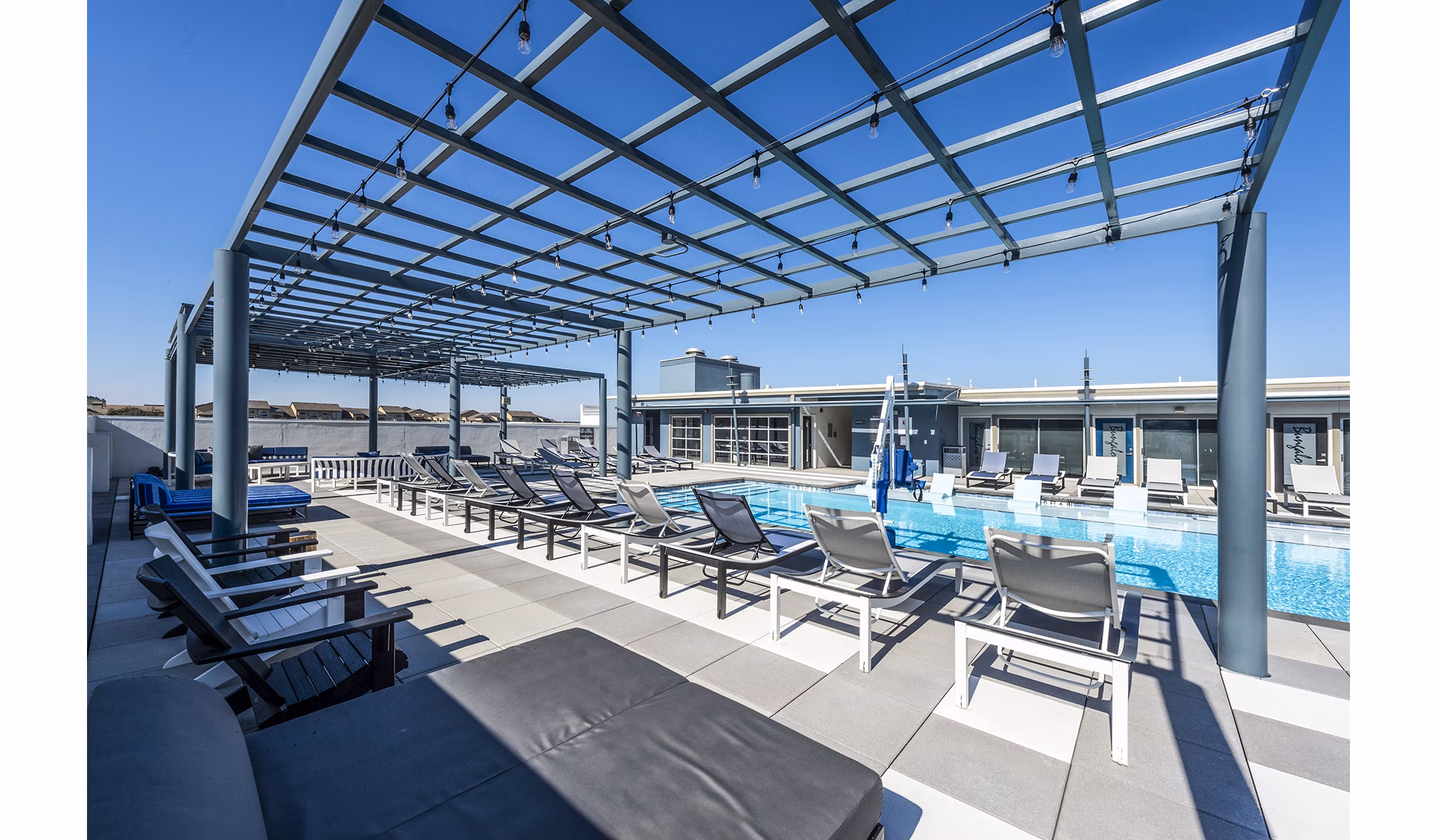 Stylish pool patio with lounge chairs and sun umbrellas at Allegro Apartments