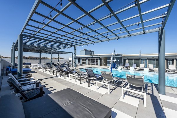 Stylish pool patio with lounge chairs and sun umbrellas at Allegro Apartments