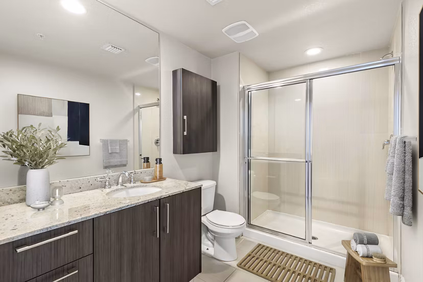 Modern bathroom featuring sleek fixtures and a glass-enclosed shower at SoMa at Brickell Apartments