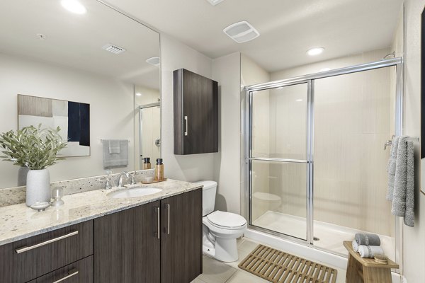 Modern bathroom featuring sleek fixtures and a glass-enclosed shower at SoMa at Brickell Apartments