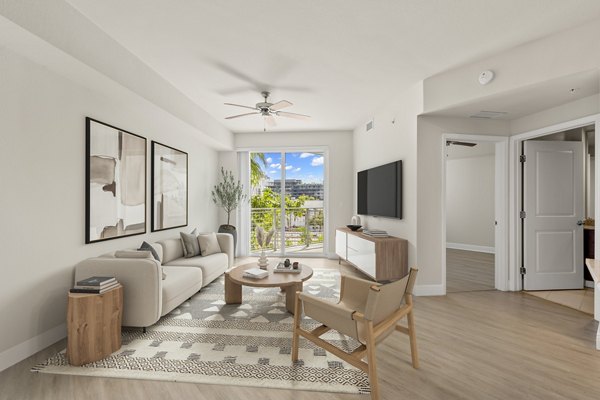 Living room with elegant decor and natural light at SoMa at Brickell Apartments