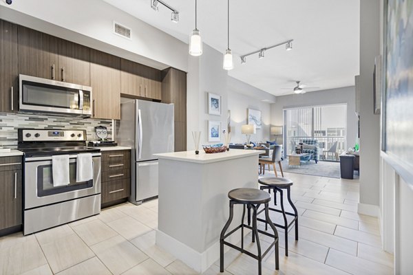 Modern kitchen with sleek countertops and stainless steel appliances at Boca City Walk Apartments, a Greystar luxury apartment community