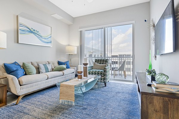 Living room with modern decor and large windows at Boca City Walk Apartments