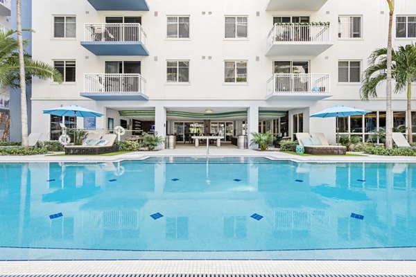 Resort-style pool with surrounding palm trees at Boca City Walk Apartments