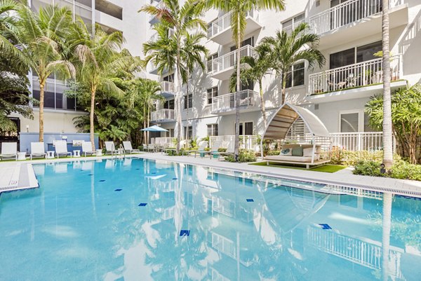 Resort-style swimming pool at Boca City Walk Apartments, offering a luxurious leisure experience with spacious sun loungers and lush landscaping