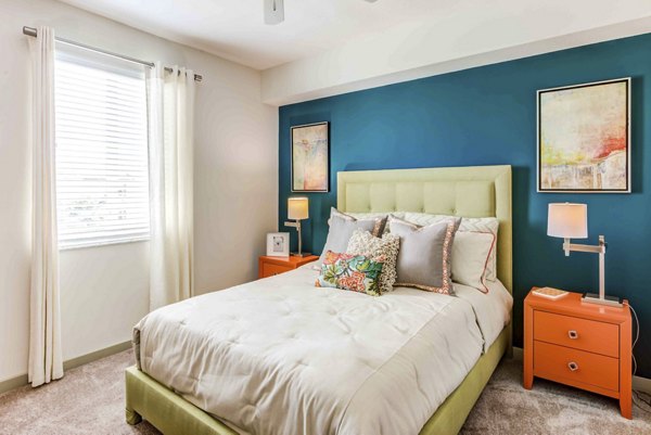 Luxury bedroom at The Franklin Delray Apartments featuring stylish decor and ample natural light