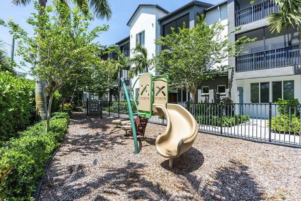 Playground area featuring modern play equipment at The Franklin Delray Apartments