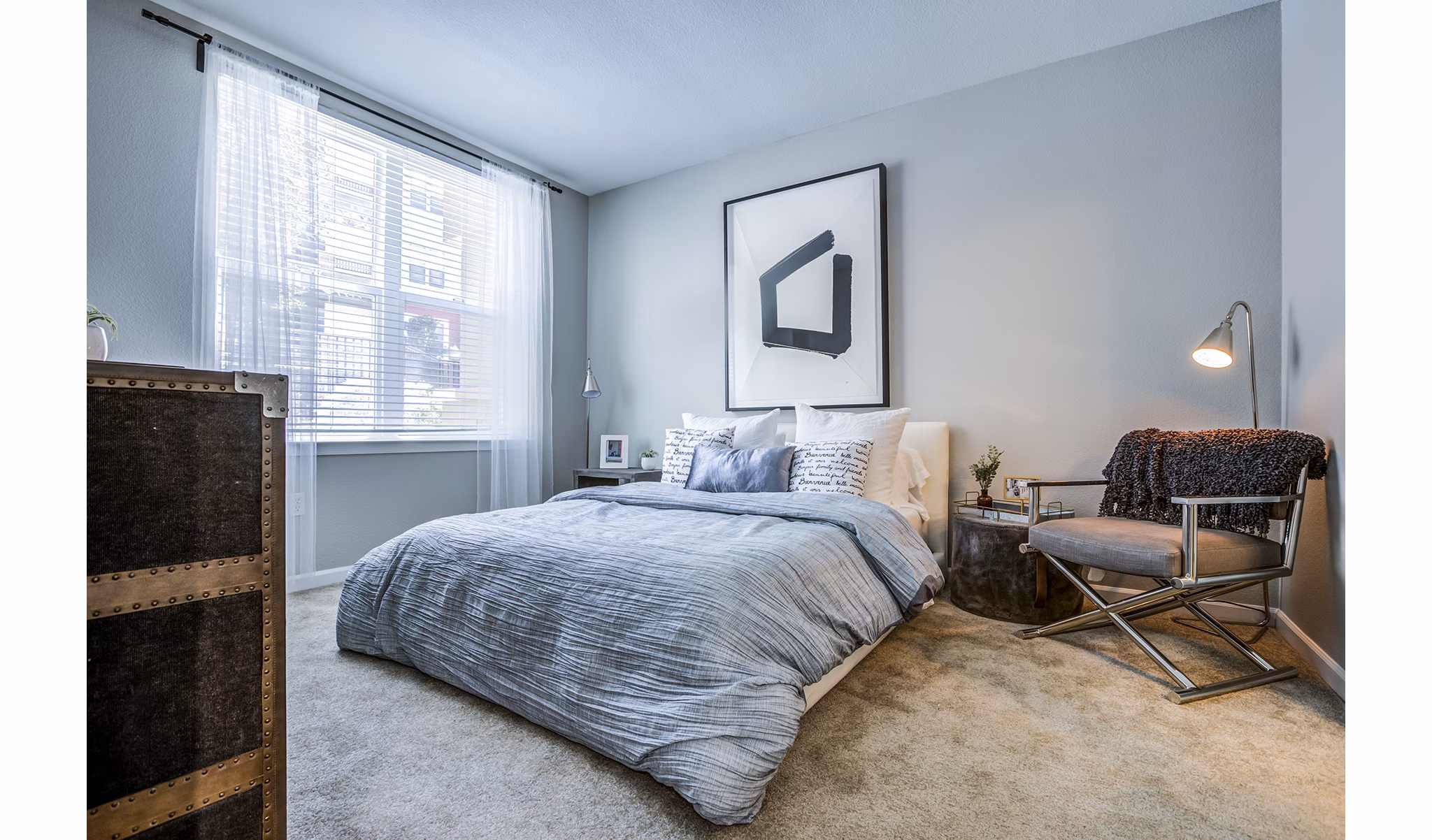 Cozy bedroom with modern furnishings in Acappella Apartments, luxury living option offered by Greystar