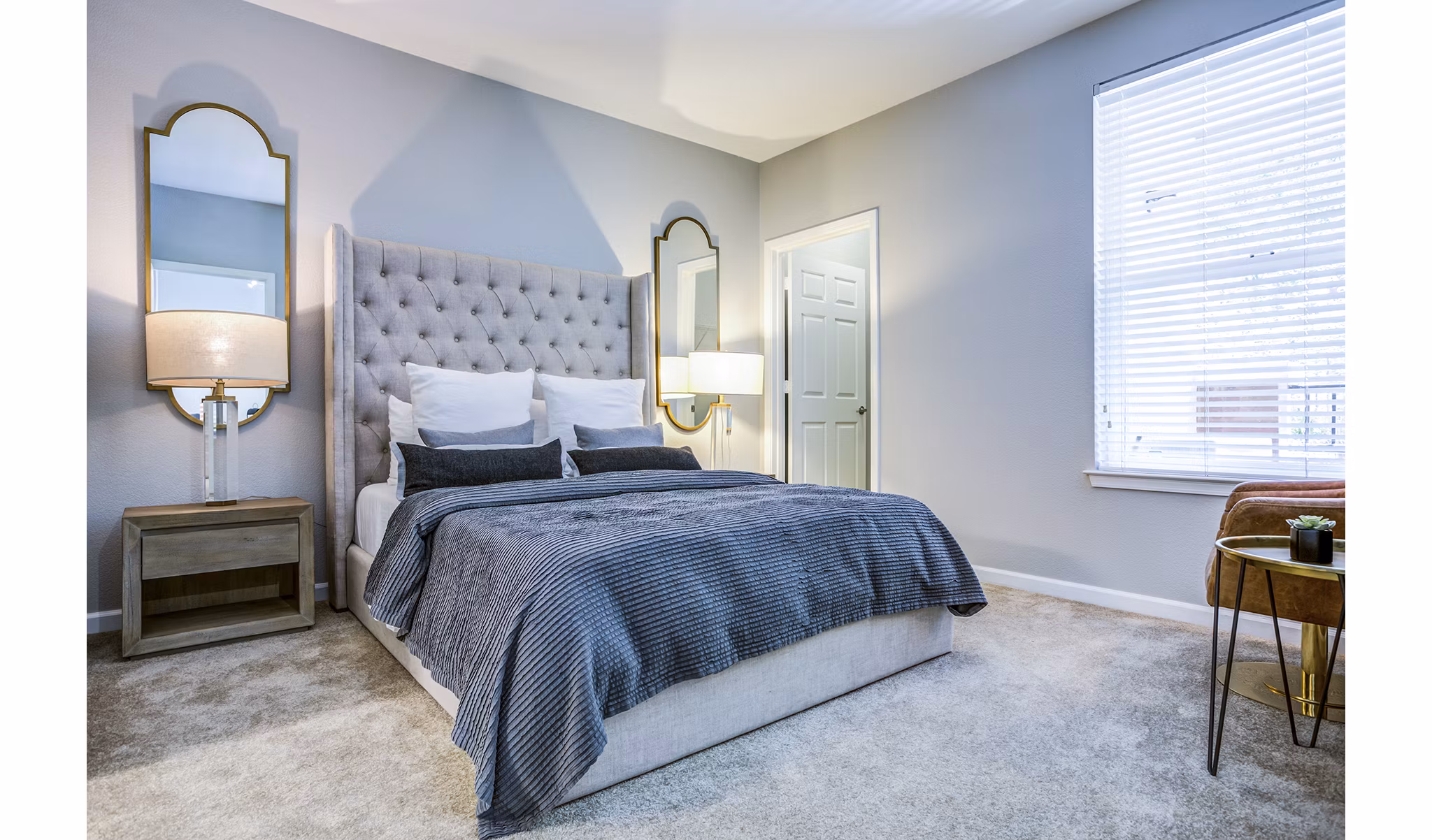 Bedroom with large windows and modern decor at Acappella Apartments
