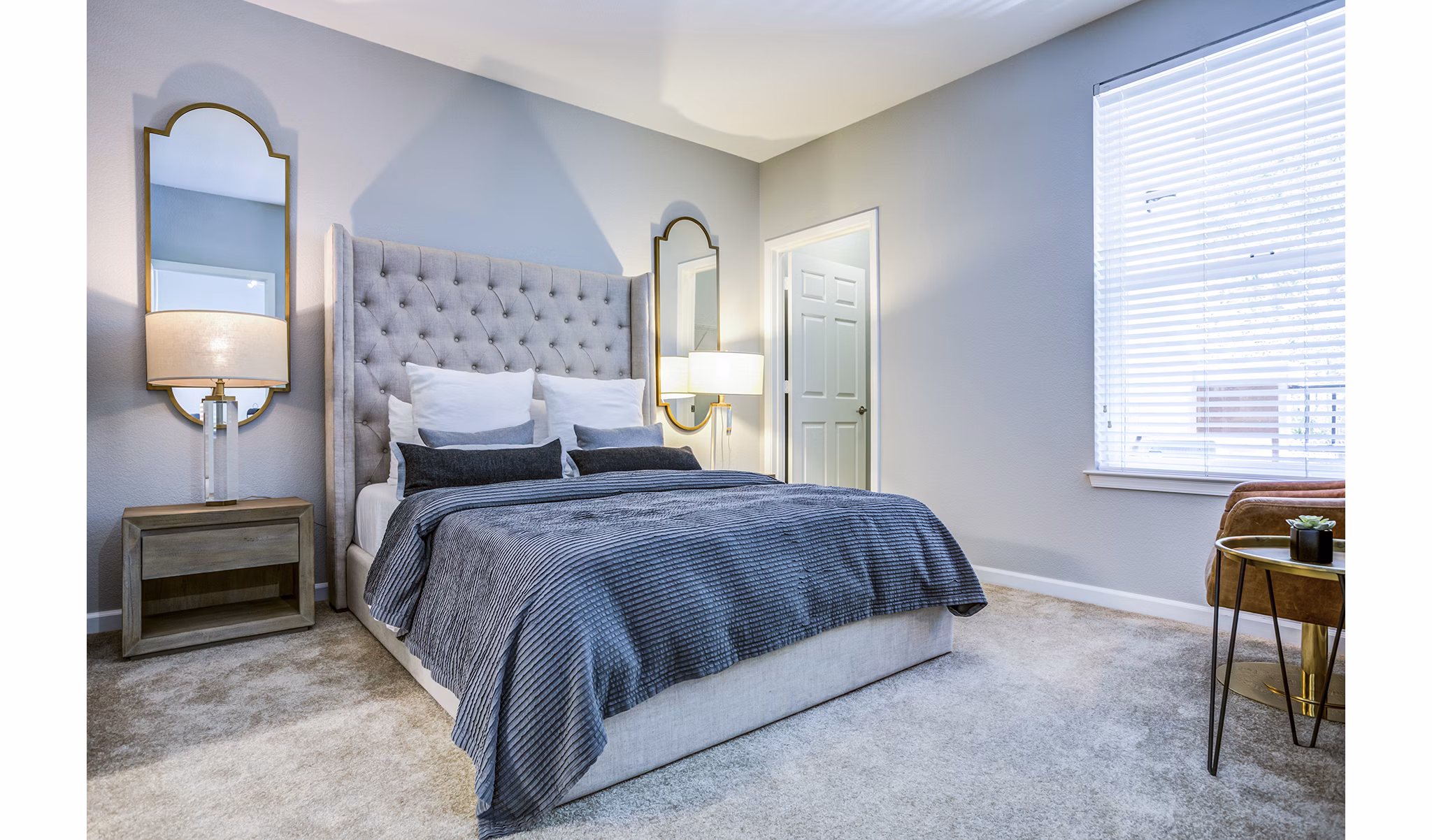 Bedroom with large windows and modern decor at Acappella Apartments