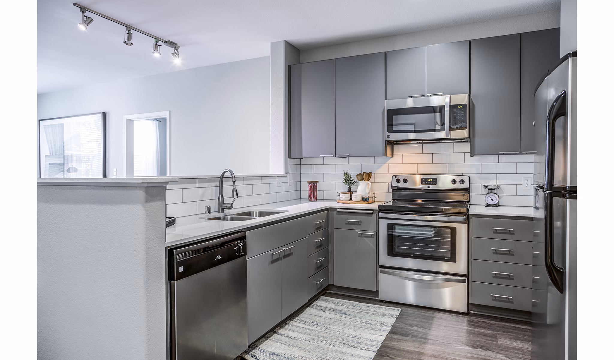 Kitchen with modern appliances and marble countertops at Acappella Apartments, luxury living spaces by Greystar