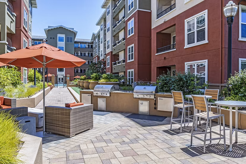 Outdoor grill area with modern cooking stations at Acappella Apartments