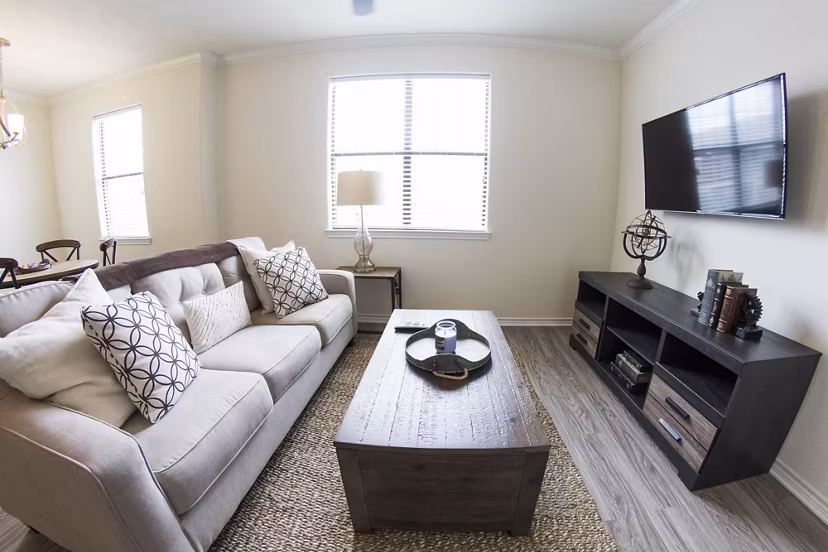 Spacious living room featuring modern decor and abundant natural light at Camber Villas Apartments