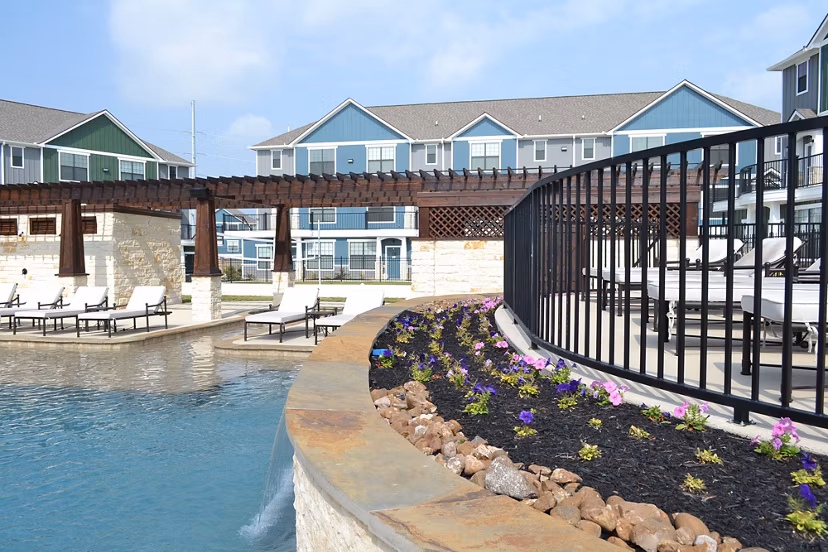 Resort-style pool with lounge chairs at Camber Villas luxury apartments