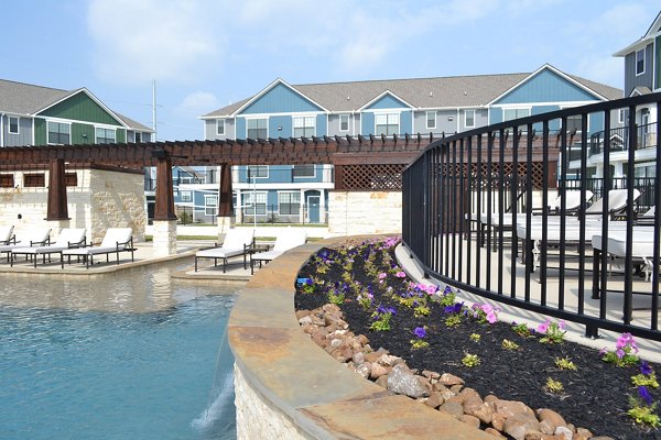 Resort-style pool with lounge chairs at Camber Villas luxury apartments