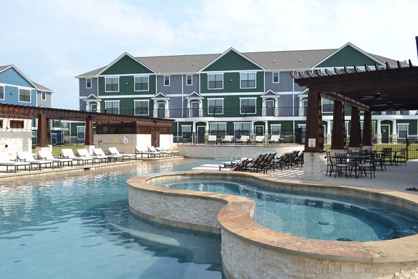 Luxury pool with sun loungers at Camber Villas, a Greystar property