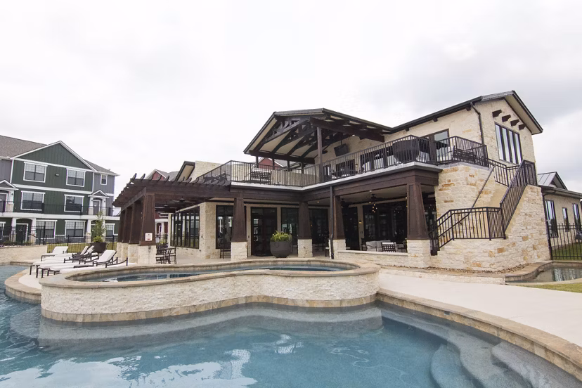 Resort-style pool with sun deck at Camber Villas Apartments, offering luxury living experiences