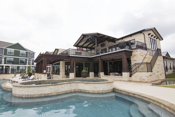Resort-style pool with sun deck at Camber Villas Apartments, offering luxury living experiences