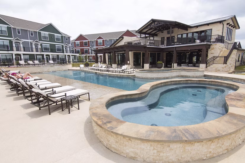 Resort-style pool with lounging area at Camber Villas Apartments