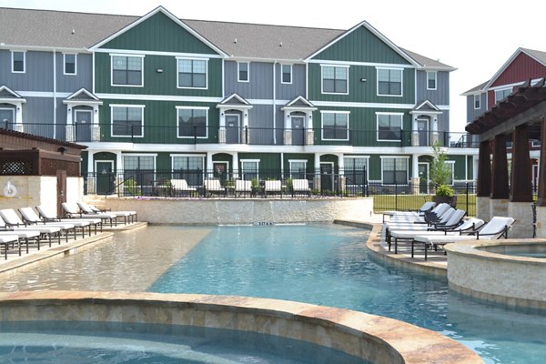 Luxurious pool area surrounded by lush greenery at Camber Villas Apartments