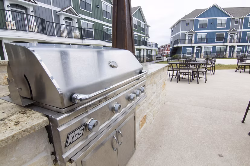 Outdoor grill area with modern seating at Camber Villas, ideal for social gatherings and barbecues in luxury apartment community