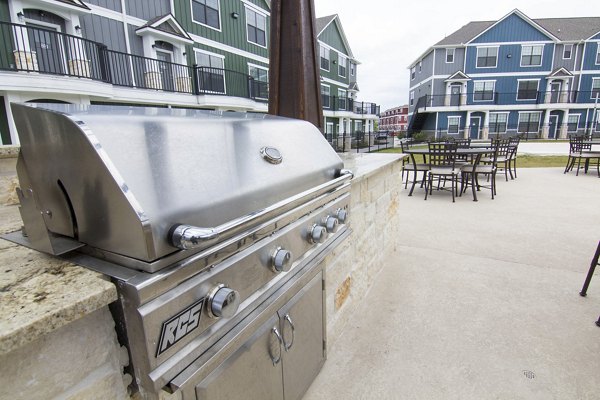 Outdoor grill area with modern seating at Camber Villas, ideal for social gatherings and barbecues in luxury apartment community